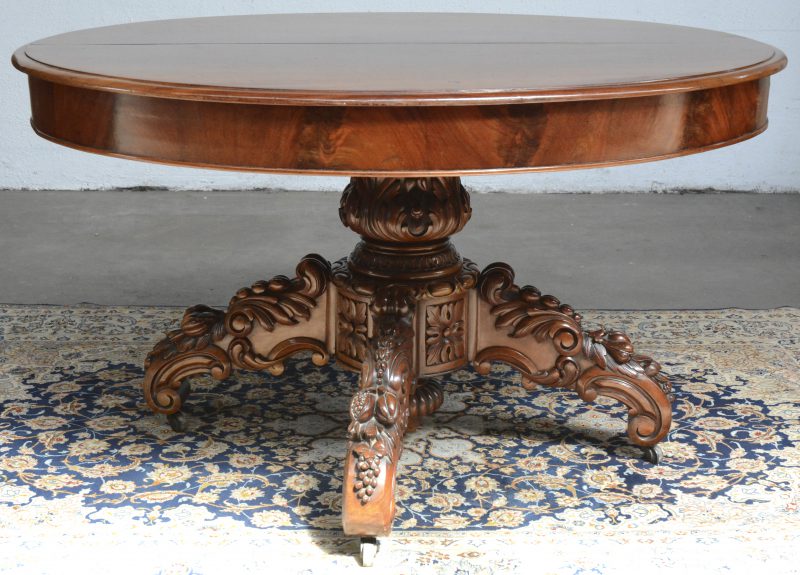 Een ovale verlengbare tafel. Gebeeldhouwde centrale vierpoot. Uitklapbare poten voor het verlengstuk. XIXde eeuw.