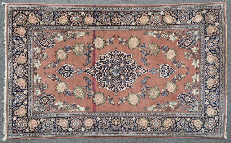 Een fijn geknoopt Oosters wollen tapijtje met decor van rozen.