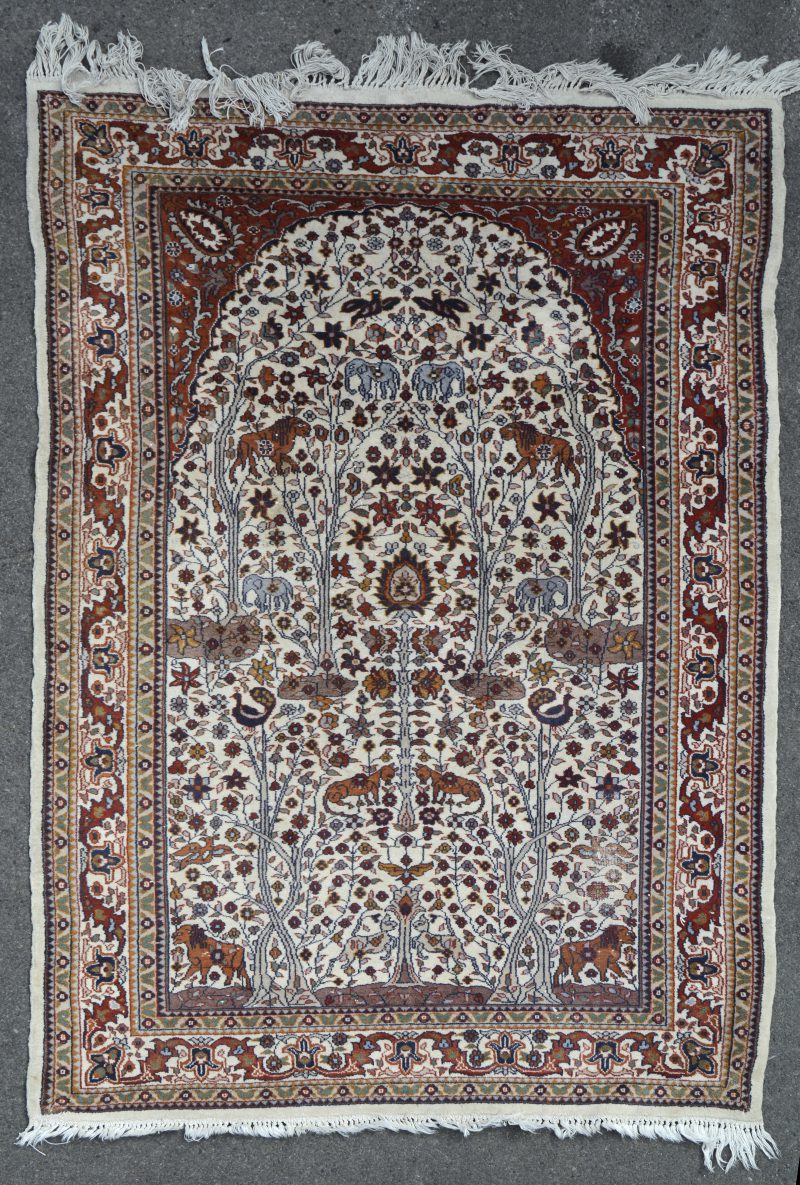Een handgeknoopt Perzisch wollen tapijtje met decor van bloeiende struiken en dieren.