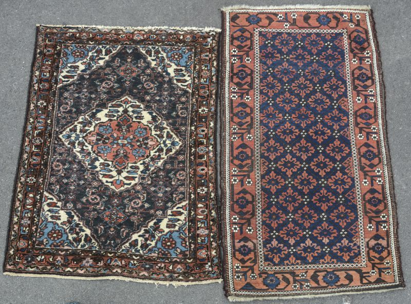 Twee kleine handgeknoopte Oosterse wollen tapijtjes.