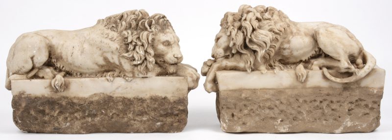 Een paar liggende leeuwen van gebeeldhouwd marmer naar Antonio Canova.