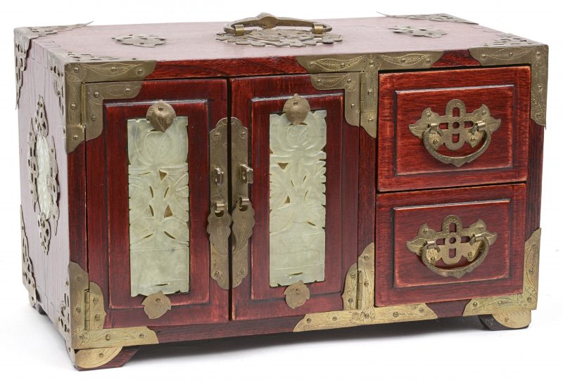 Een Chinees juwelenkastje met vijf schuifjes, versierd met jade plaquettes en met messingen beslag.