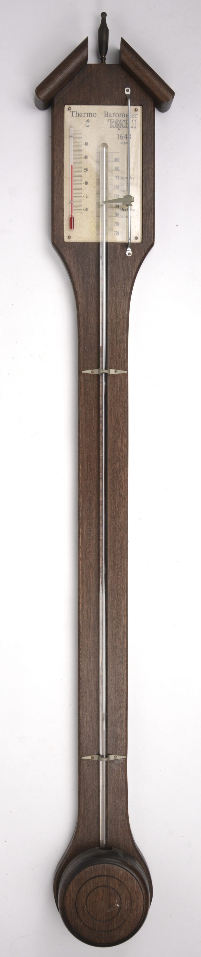 Een barometer - thermometer op houten muurplank.