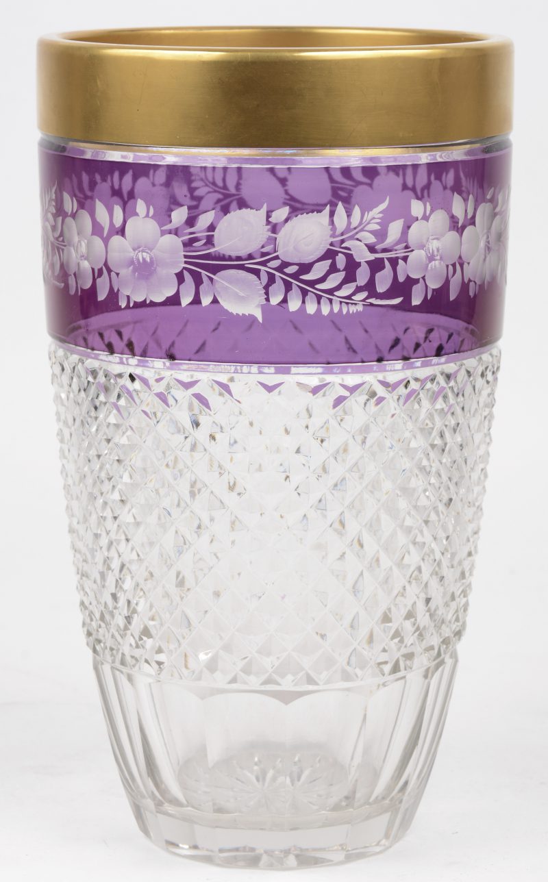 Een geslepen kristallen vaas, versierd met bloemen in een paarse fries en me vergulde rand.
