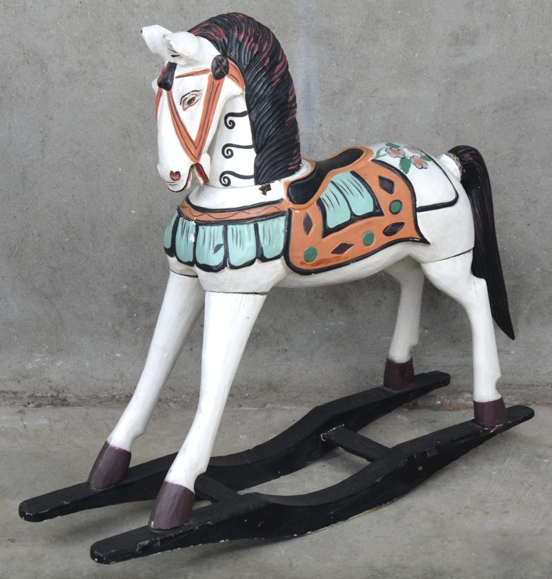 Een oud houten schommelpaard met handgeschilderde versieringen.