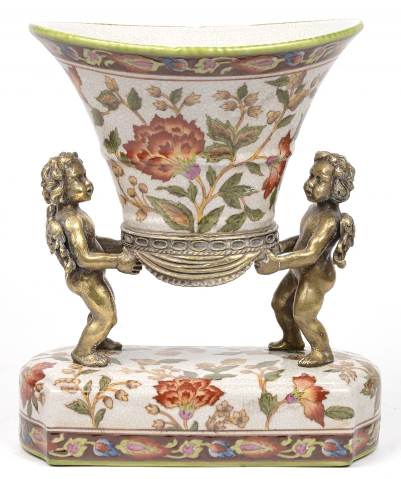 Een siervaas van meerkleurig porselein met bloemendecor en gedragen door twee bronzen engeltjes. Onderaan gemerkt.
