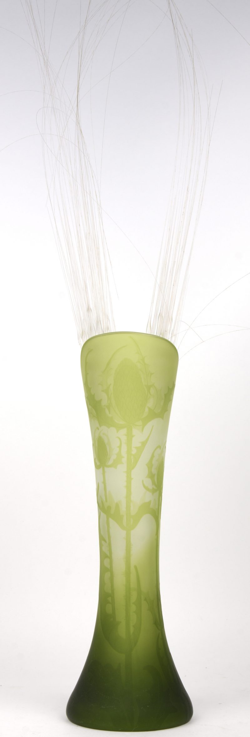 Een vaas van groen glas met een geëtst decor van distels. Gemerkt.