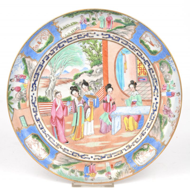 Een bord van Chinees porselein met een meerkleurig decor van lange lijzen.