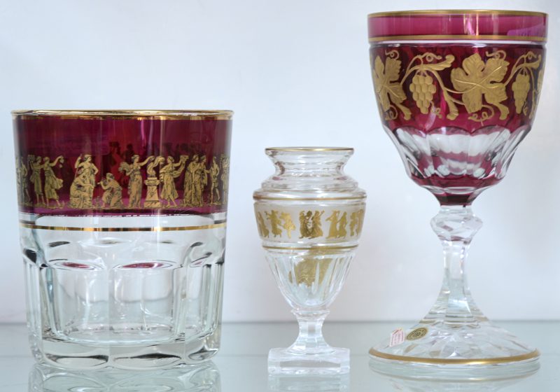 Een wijnglas en een miniatuur vaas van geslepen kristal, beide versierd met verguld decor in een fries. Het vaasje genummerd 103/ 250 en gedateerd 1993. Bijgevoegd een glazen vaas, eveneens met verguld decor.