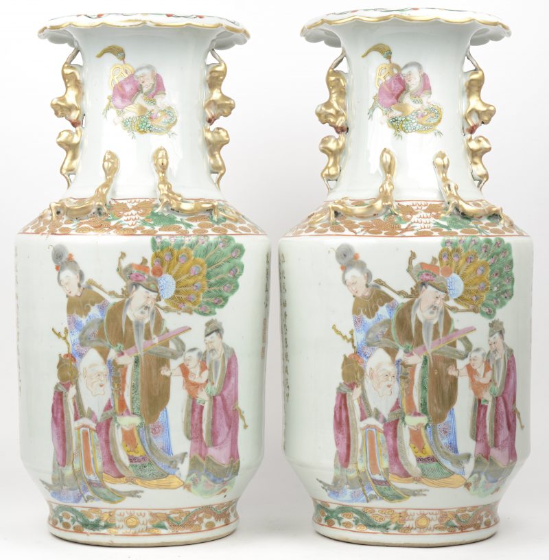 Een paar vazen van Chinees porselein met meerkleurig en verguld decor van personages en met aapjes en draakjes in reliëf.