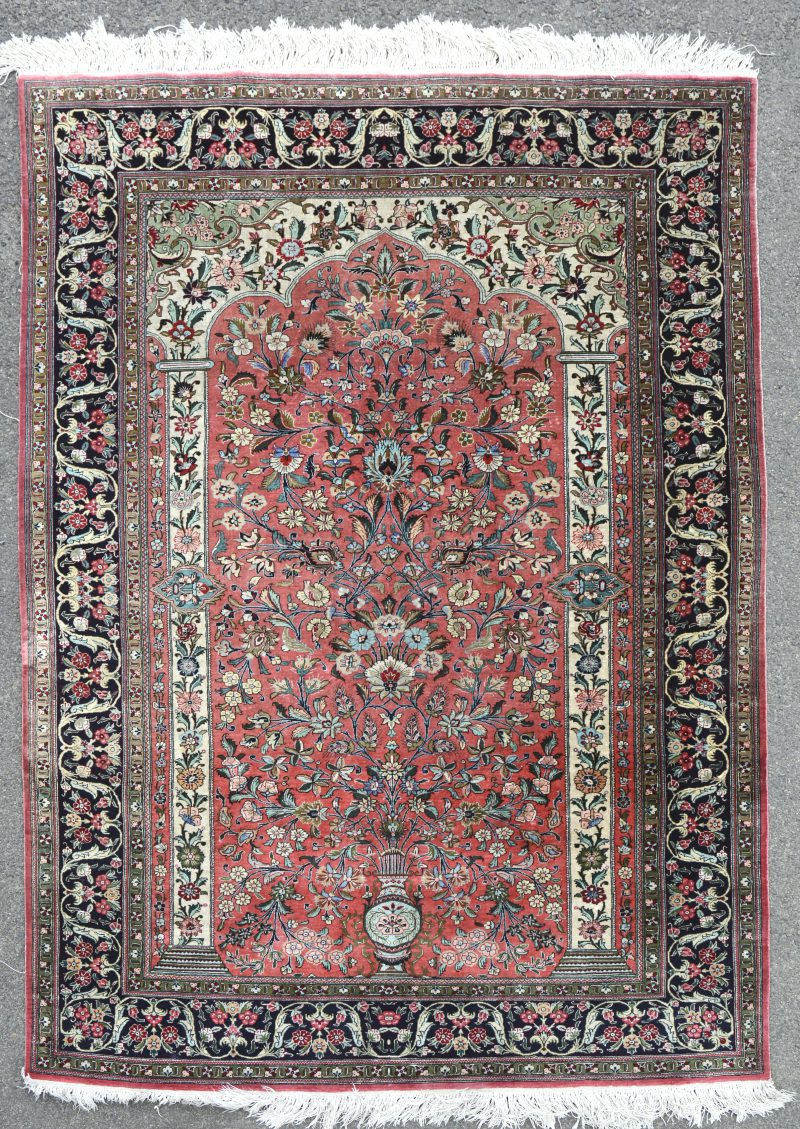 Een handgeknoopt Perzisch karpet van zijde met een decor van een bloemenvaas.