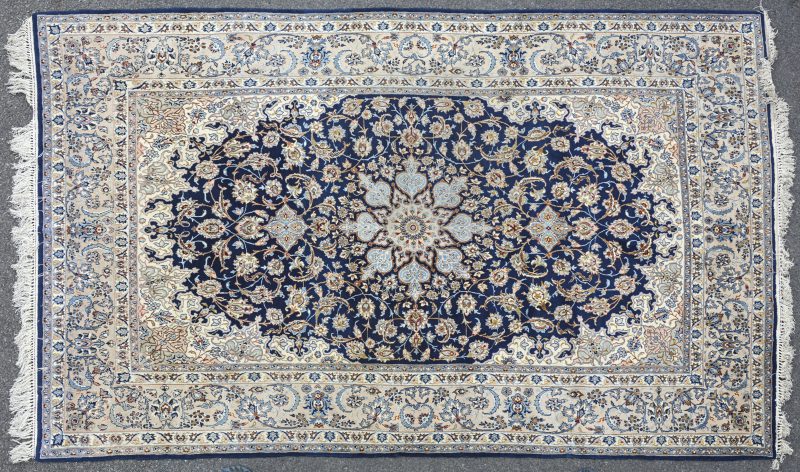 Een handgeknoopt Perzisch wollen tapijtje van zijde.