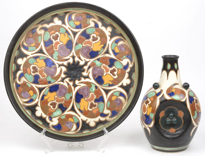 Een schotel en een kruikje van Gouds aardewerk met decor ‘Kalman’. Onderaan gemerkt.