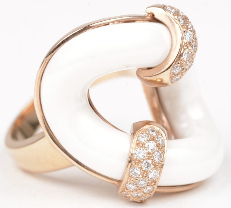 Een 18 karaats rooskleurige gouden ring bezet met briljanten met een gezamenlijk gewicht van ± 0,64 ct. en agaat.