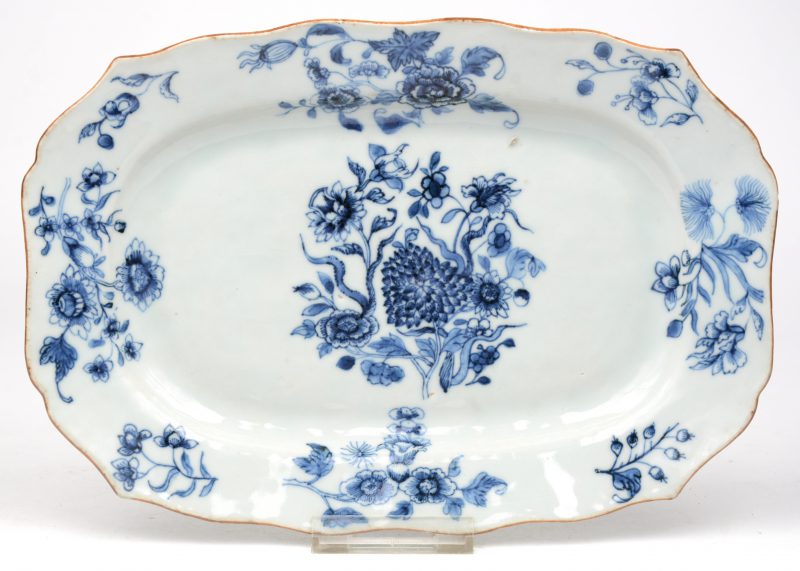 Een rechthoekig schoteltje van blauw en wit Chinees porselein. Decor van bloeiende takken, accoladerand. Tijdperk Qinglong.