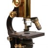 Een oude microscoop met toebehoren in houten kastje.