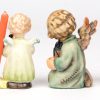 “Tunefull angel”; “Guiding angel” & “Shining light angel”. Drie beeldjes van meerkleurig biscuit uit de reeks van M.I. Hummel. Onderaan gemerkt. No 359, 357 & 358. Bijgevoegd een engeltje met speelgoedpaard met kaarsje.