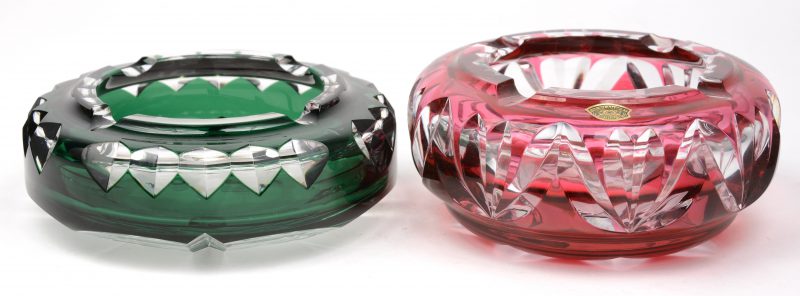 Twee asbakken van geslepen kristal, waarbij één rood en de andere groen gedubbeld. Beide gemerkt, de rode genummerd MPU 83/155.