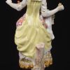 “Jonge vrouw met bloemen”. Een beeldje van meerkleurig Duits porselein. Gemerkt met gekruiste degen. Enige schade aan de jurk. XIXe eeuw.