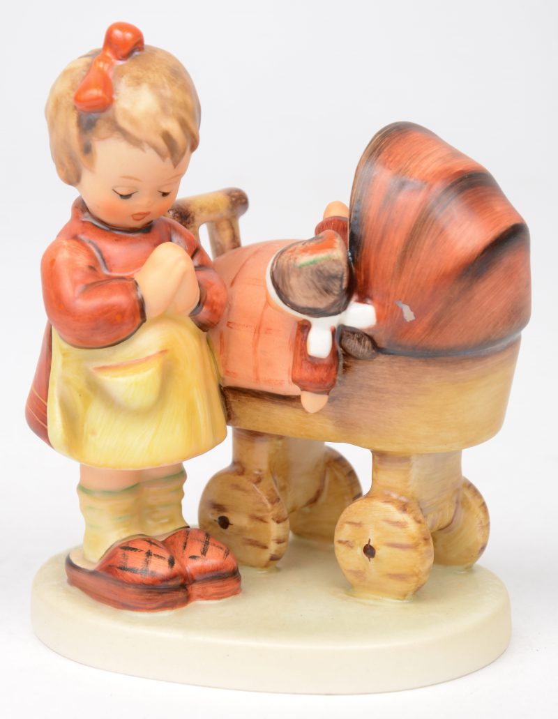 “Puppenmütterchen”. Een beeldje van meerkleurig biscuit uit de reeks van M.I. Hummel. Gemerkt onderaan. No. 67.