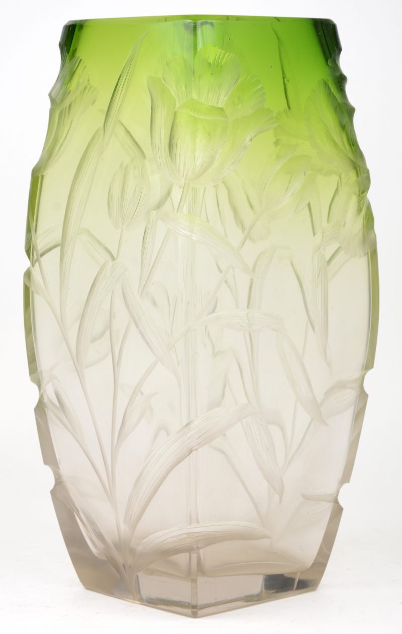 Een vaas van groen en kleurloos glas met reliëfdecor van bloemen.