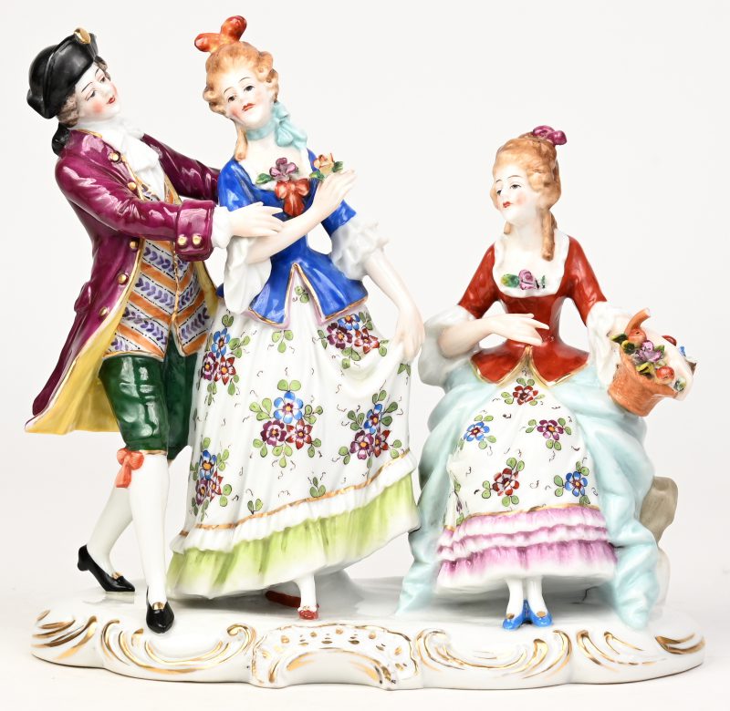 Een elegante groep met drie personages van veelkleurig porselein. Onderaan gemerkt.