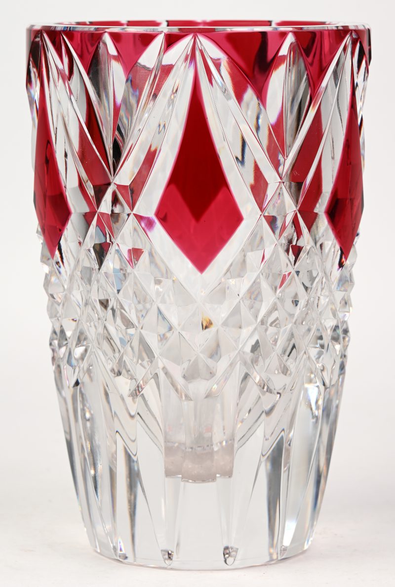 Een vaas van geslepen kleurloos en rood kristal. Onderaan gemerkt en genummerd ‘P.U. 602/89’.