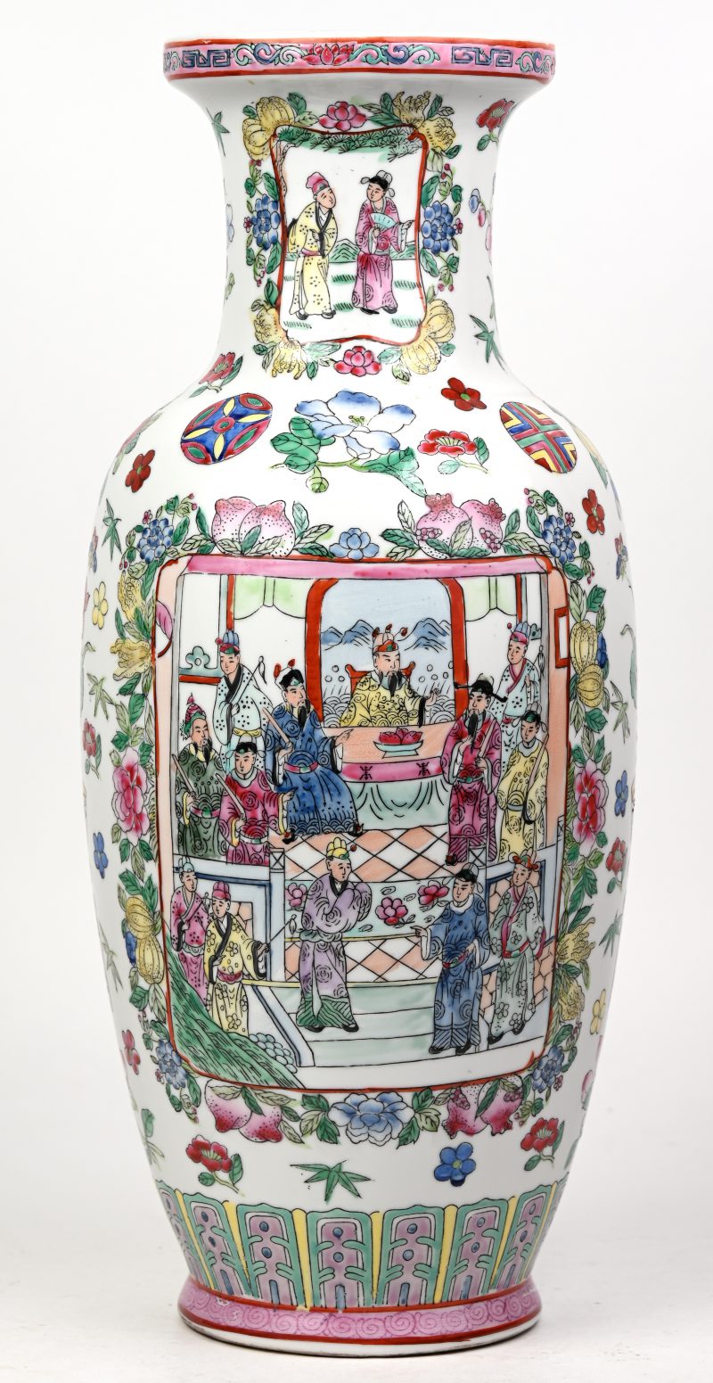 Een vaas van Chinees porselein met een meerkleurig decor van hofscènes in cartouches, omgeven door bloemen. Onderaan gemerkt.