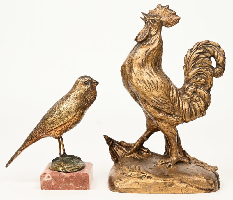 Een bronzen haan met goudkleurig patina. Gesigneerd. Eerste helft XXe eeuw. We voegen er een soortgelijk vogeltje op rood marmeren sokkeltje aan toe.