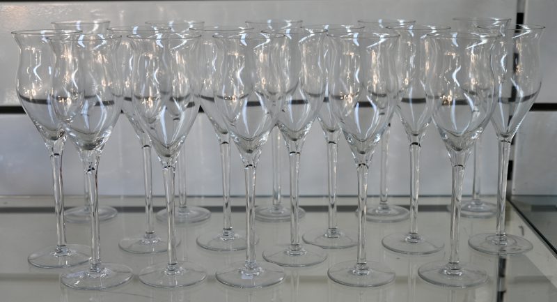 Een reeks van zeventien kleurloos halfkristallen champagneglazen.