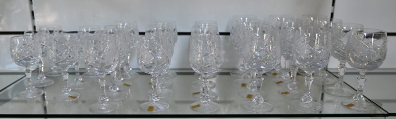 Een geslepen kleurloos kristallen glazenservies, bestaande uit twaalf rodewijnglazen, twaalf wittewijnglazen en zes aperitiefglazen.