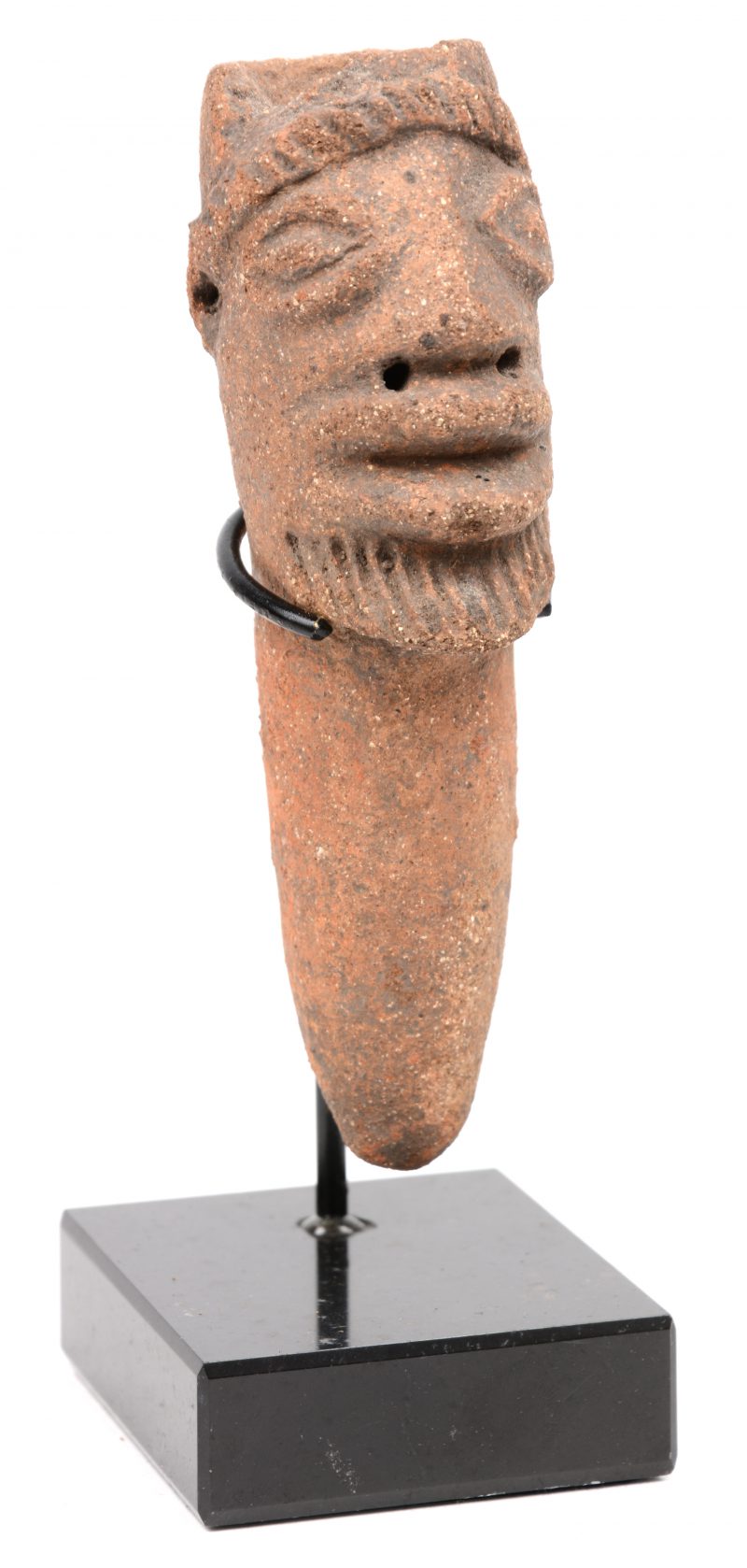 Een aardewerk beeldje in de vorm van een hoofd afkomstig uit het noorden van Ghana. 16e eeuws. Op een sokkel.