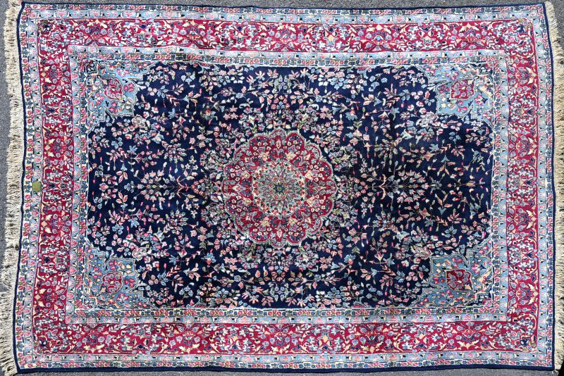 Een Oosters wollen tapijt. Blauw in het midden.