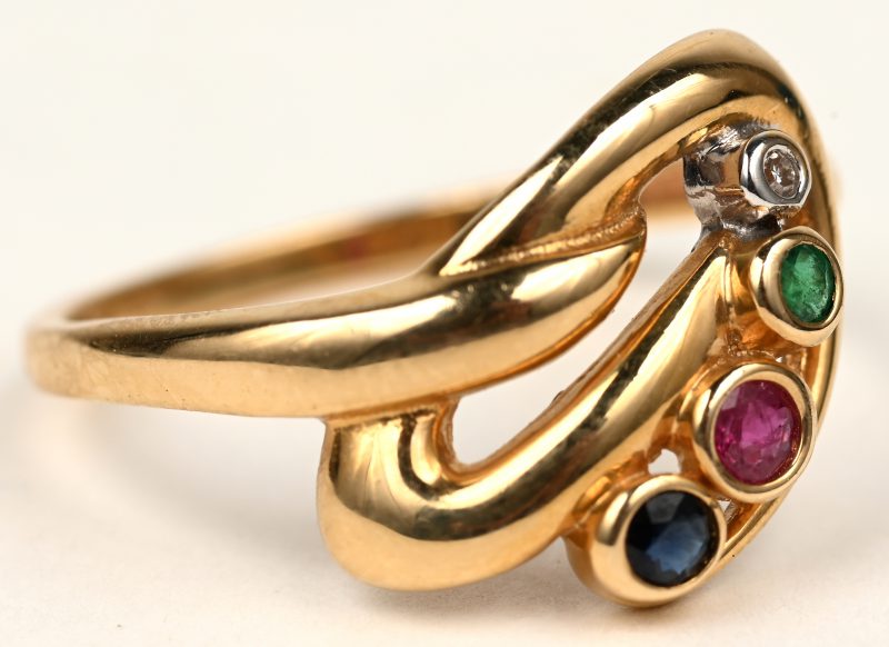 Een 18 K geelgouden ring bezet met één briljantje, één saffier, één robijn en één smaragd met een gezamenlijk gewicht van +- 0,20 ct.