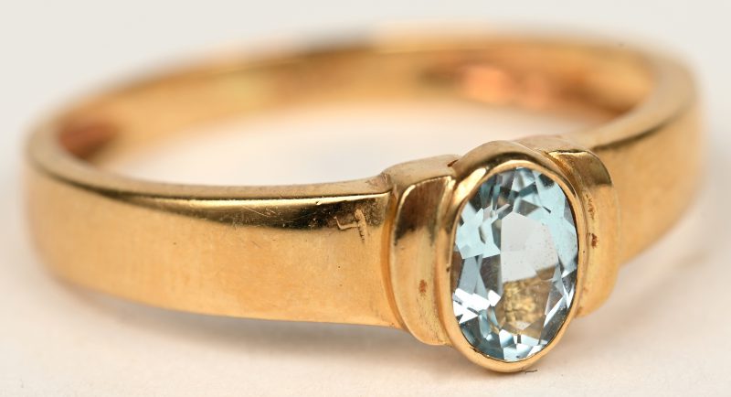 Een 18 K geelgouden ring bezet met een ovale aquamarijn van +- 0,50 ct.