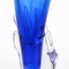 Een kelkvormige vaas opgehouden door een hand van kleurloos en blauw kristal.