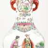Een vaas van Chinees porselein met olifanten als handvatten en versierd met diverse figuren.