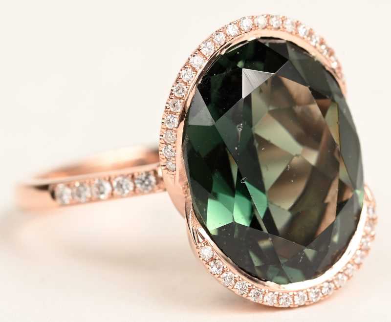Een 18 K roze gouden ring bezet met briljanten met een gezamenlijk gewicht van +- 0,20 ct. en een in briolet geslepen tourmalijn van +- 7,64 ct.