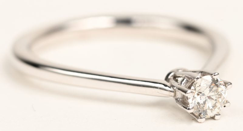 Een 18 K witgouden ring bezet met een solitair van +- 0,20 ct.
