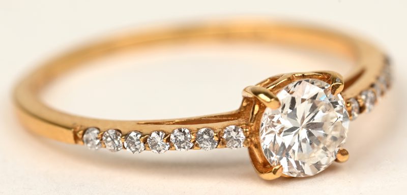 Een 18 K geelgouden ring bezet met briljanten met een gezamenlijk gewicht van +- 0,18 ct. en een centrale briljant van +- 0,40 ct.