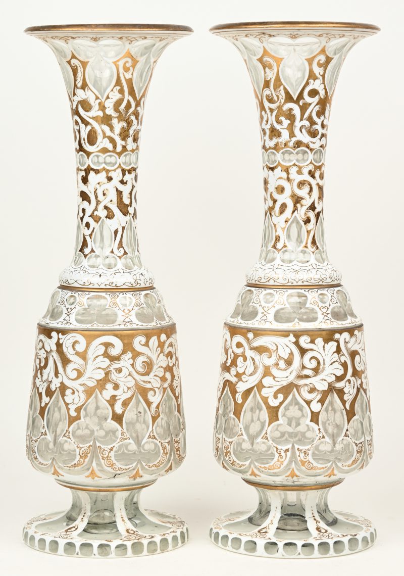 Een paar glazen Louis-Philippe vazen met een wit en verguld overlay decor van guirlandes. Einde XIXde eeuw.