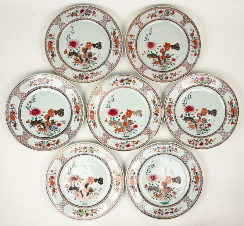 Een serie van zeven porseleinen borden met een famille rose decor van bloemenvazen en met bloementuilen in vier uitsparingen op de vleugel. Chinees werk, XIXde eeuw. Enkele kleine randschilfers, wat slijtage aan sommige decors.