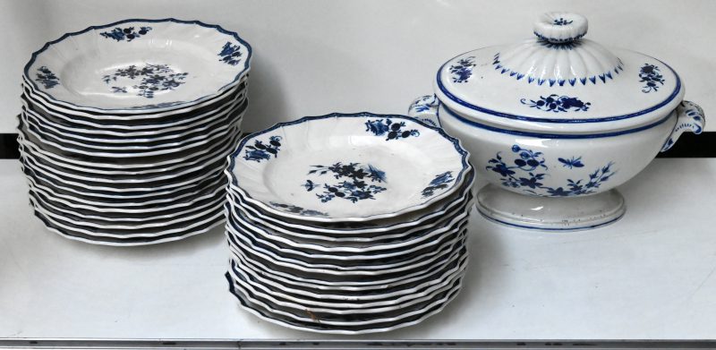 Een serie van 32 borden van zachte pasta met een blauw en wit decor à la mouche. Vier bloementuilen op de vleugel met getorste ribben, gecontourneerde rand. Evenals een soortgelijke soepterrine. Doornik, XIXde eeuw.
