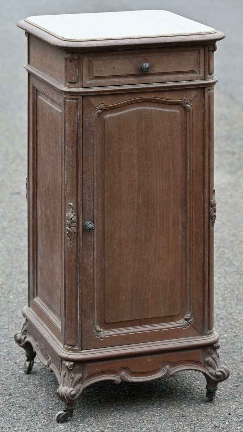 Een bijzetkastje/ nachtkastje van kerselaar in Lodewijk XV-stijl met een deurtje en een lade, een marmeren blad en op wieltjes.