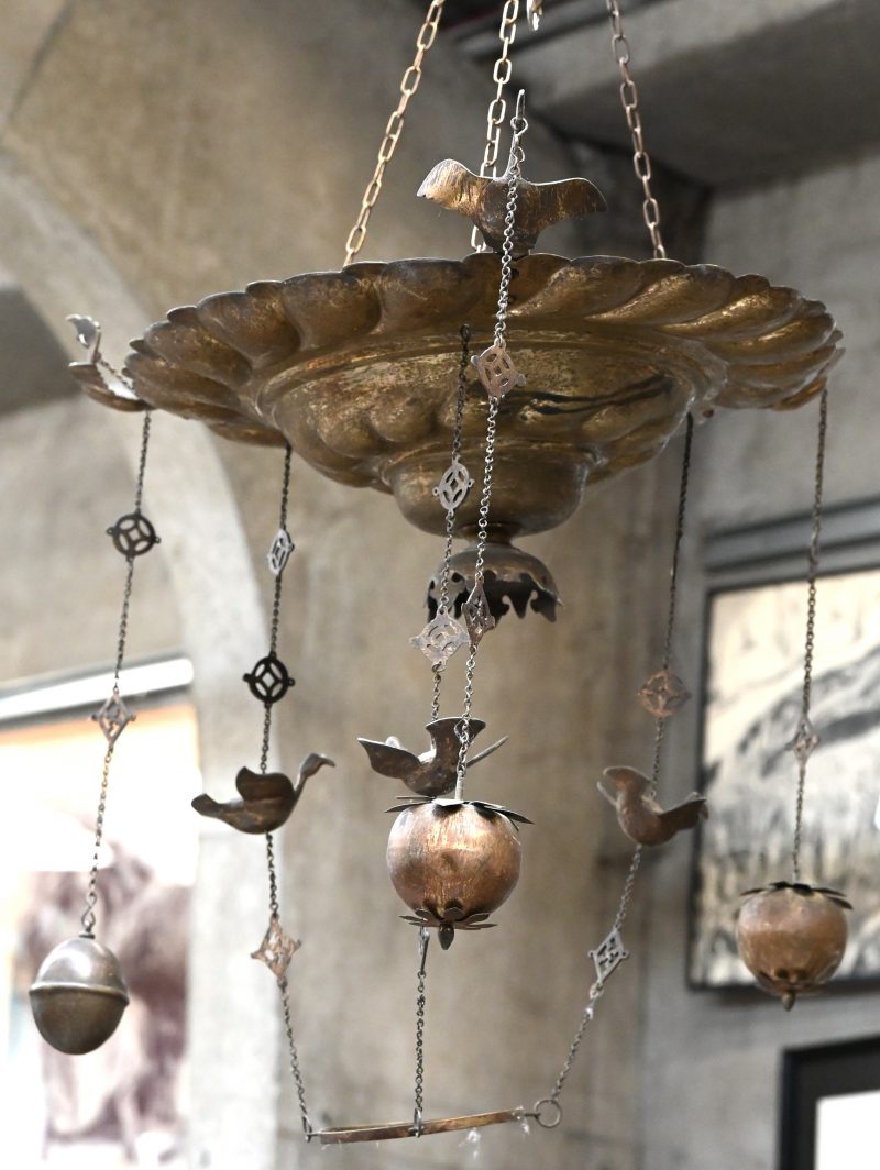 Een gedreven koperen godslamp, versierd met vogeltjes.