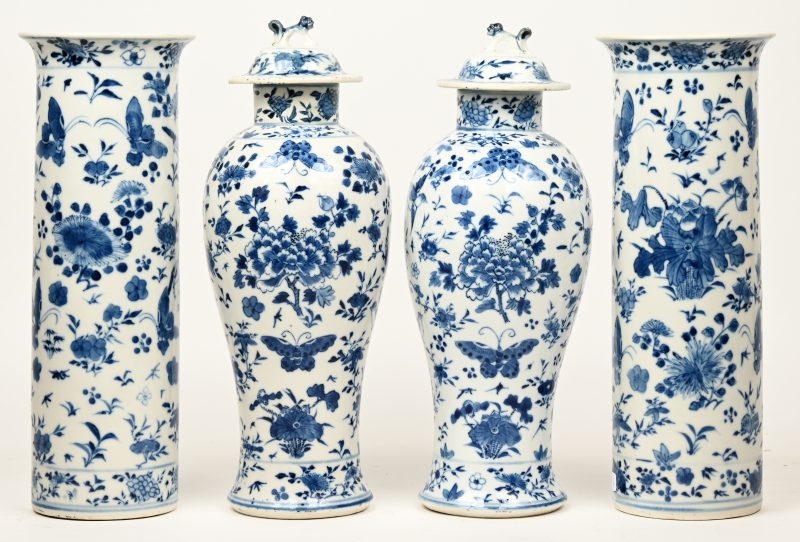 Een vierdelig kaststel van Chinees porselein, bestaande uit twee dekselvazen en twee cilindervazen, versierd met een blauw op wit decor van bloemen en vogels. Onderaan gemerkt.