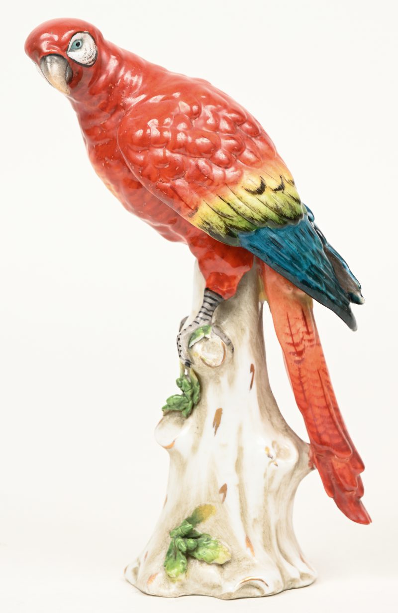 Een antieke papegaai van meerkleurig Saksisch porselein. Gemerkt met gekroonde N. Een blaadje beschadigd.