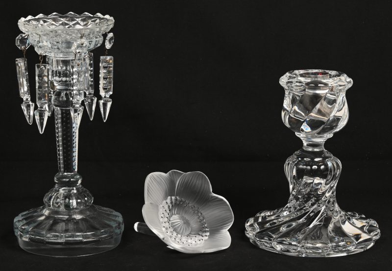 Een kandelaar van kleurloos kristal. Gemerkt van Baccarat. Bijgevoegd een gesatineerd kristallen bloem met onleesbaar merk en een gegoten glazen kandelaar met pegeltjes.