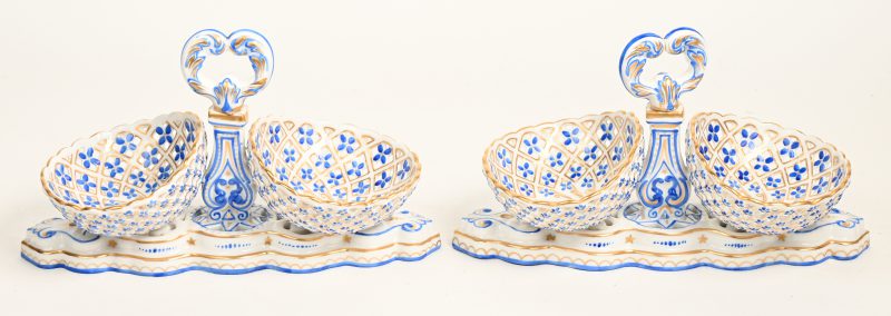 Twee opengewerkte dubbele schaaltjes van Saksisch porselein met blauw en verguld decor. Onderaan gemerkt.