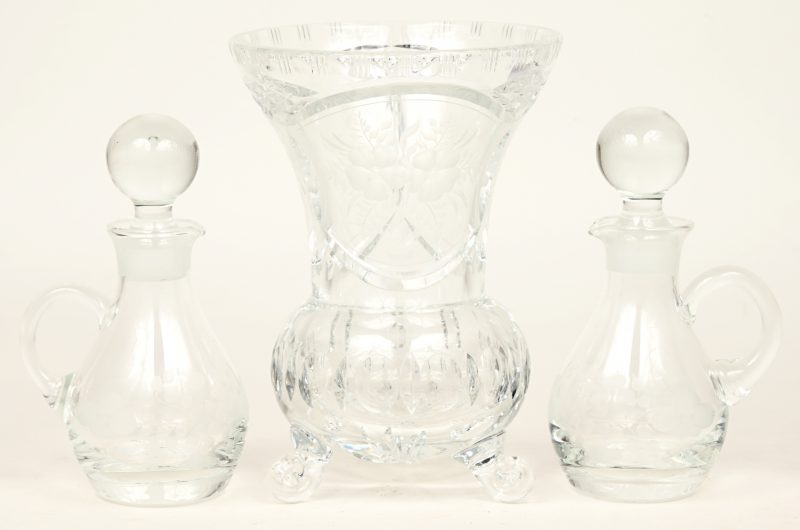 Een lot kleurloos kristal, bestaande uit een vaas en twee kleine karafjes, alledrie versierd met geslepen bloemendecors.